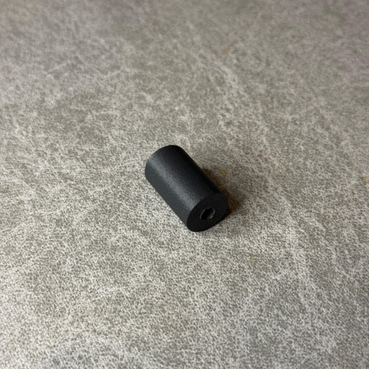 Black cylindrical object on a gray concrete surface