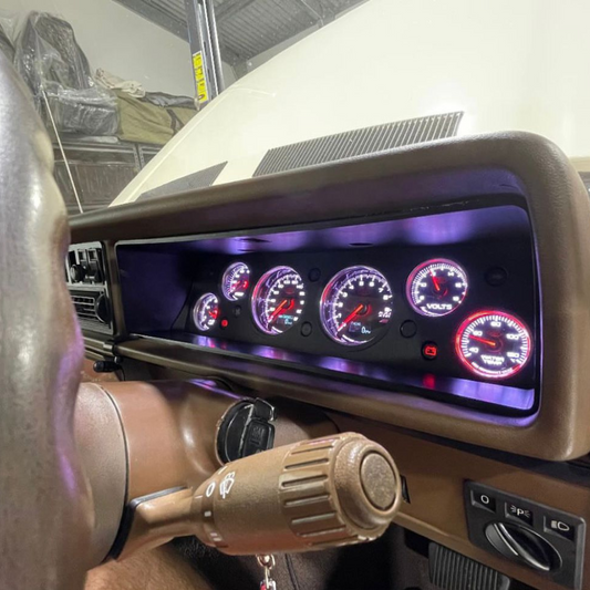 Car dashboard with digital gauges (Instrument Cluster Replacement) and controls in a garage setting