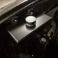 Close-up of a car's SAAS Windscreen Washer Bottle on a black engine cover.