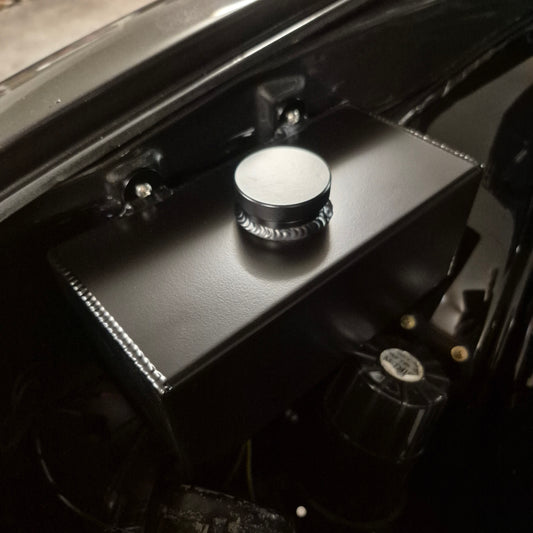 Close-up of a car's SAAS Windscreen Washer Bottle on a black engine cover.