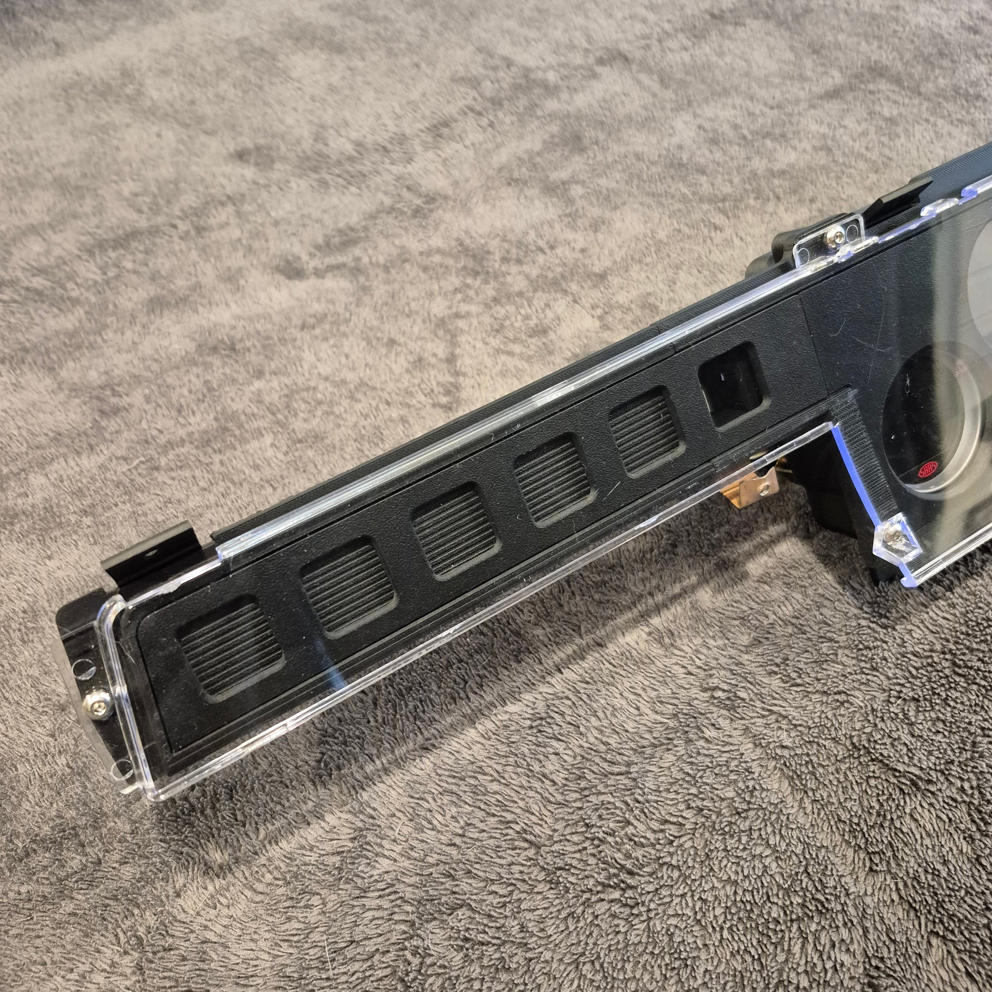 Black metal bracket or component on a textured gray surface