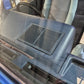 Car interior with a speaker grille and window control panel.