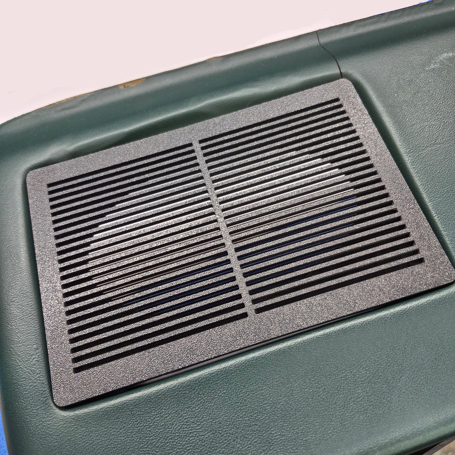 Black textured mat on a green surface