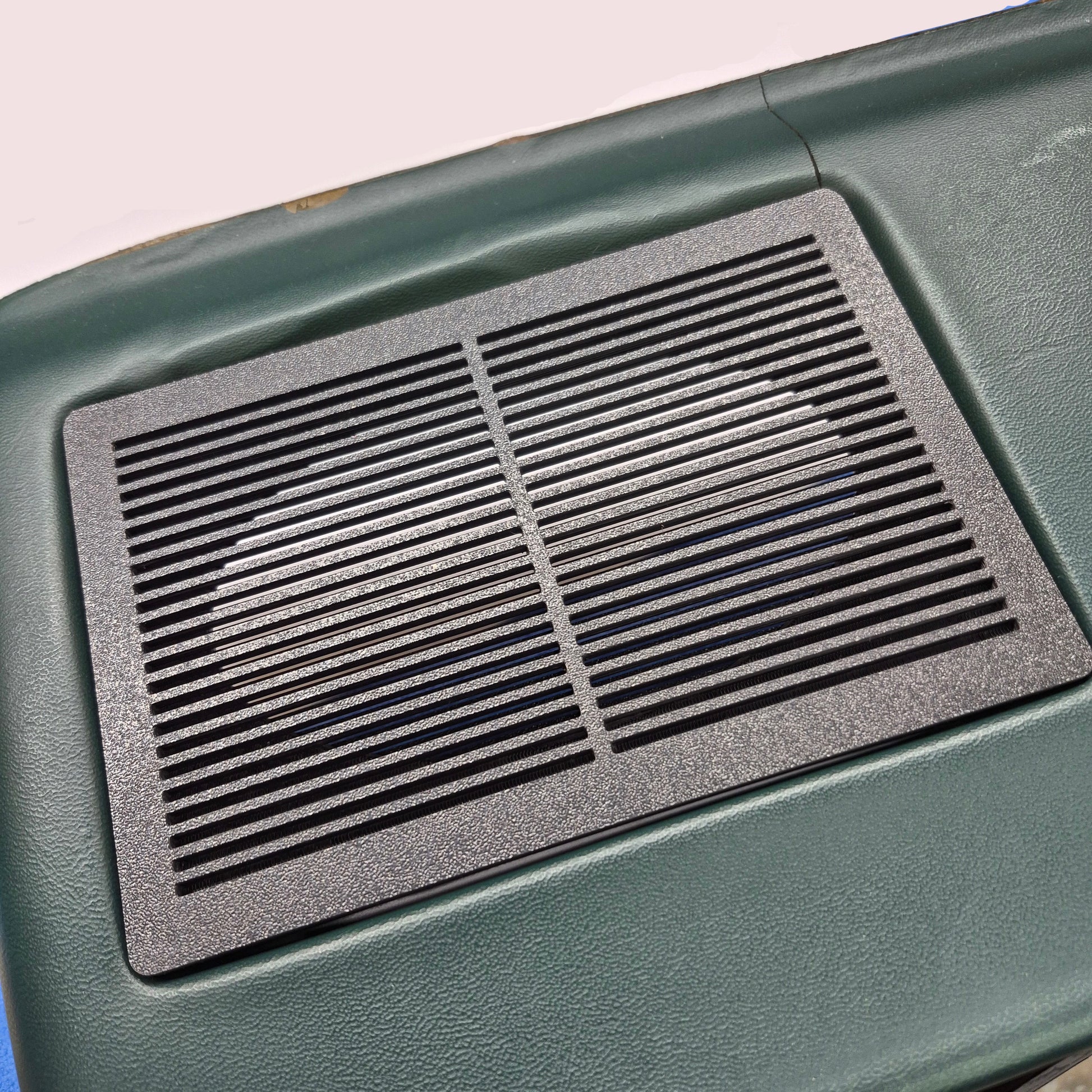Black textured mat on a green surface
