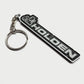 A black and silver Holden keychain featuring the brand's name and logo, attached to a silver split key ring, set against a plain light gray background.