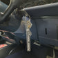 A silver metal car keychain with a black and white vertical 'HOLDEN' logo and a horse emblem, hanging from a key in a vehicle's ignition.