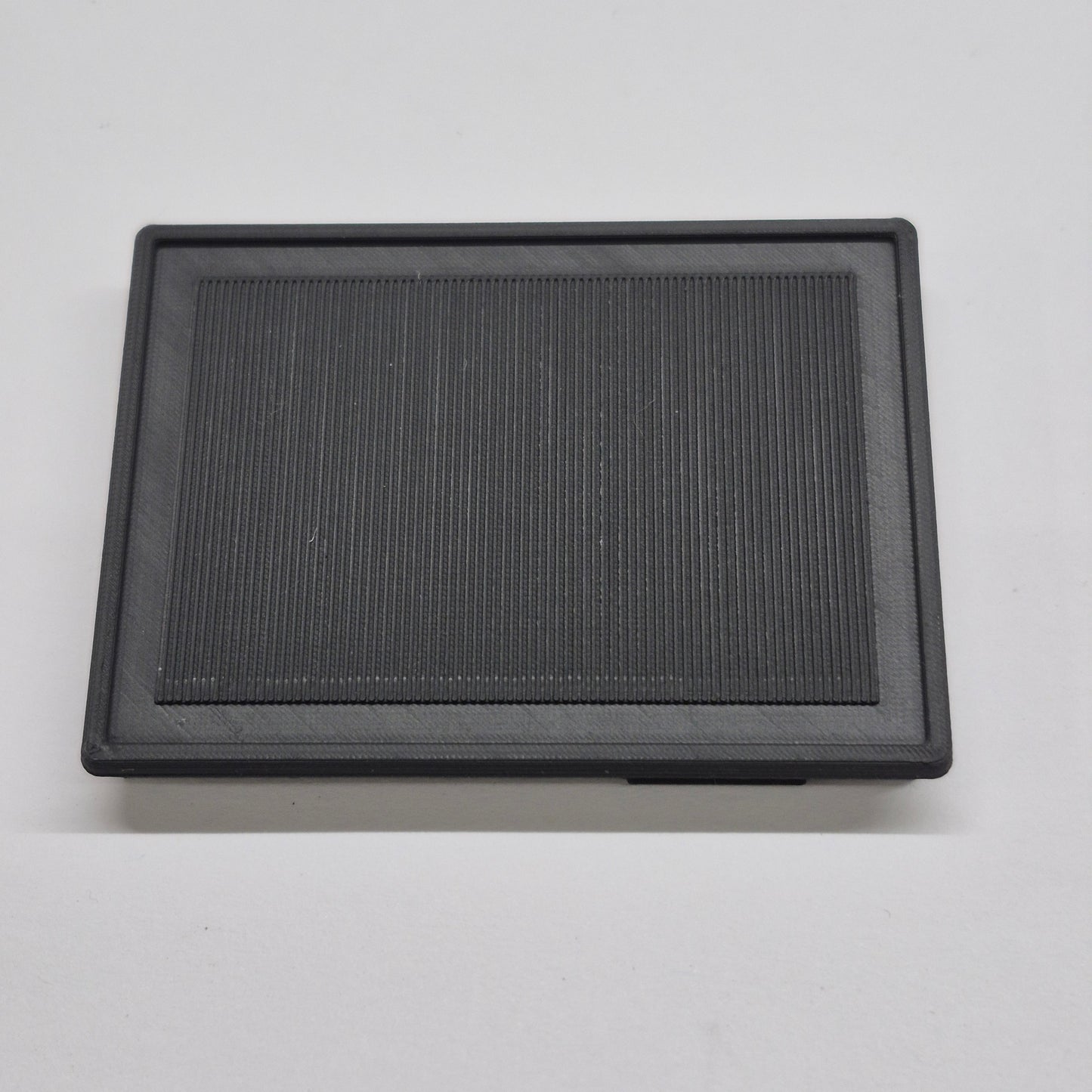 Black rectangular air filter on a light gray background