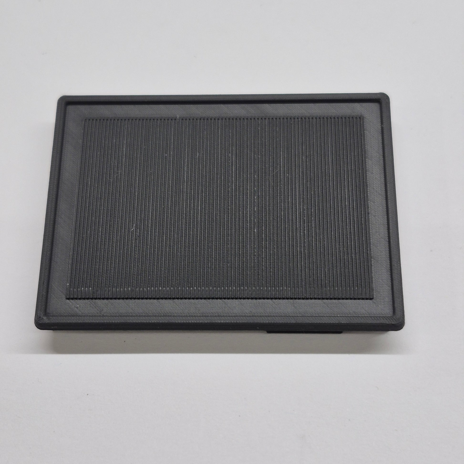 Black rectangular air filter on a light gray background