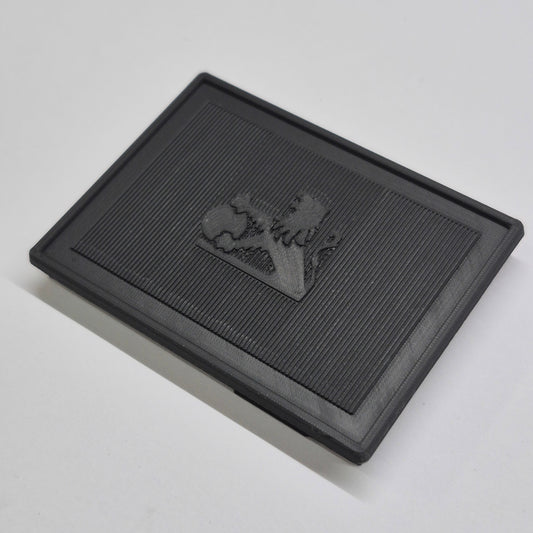 Black textured square mat with a logo on a light gray background