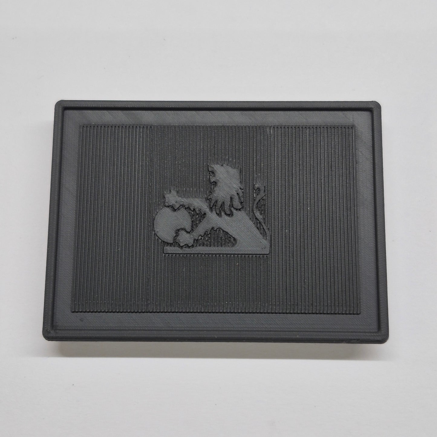 Black rectangular mat with a lion emblem on a gray background