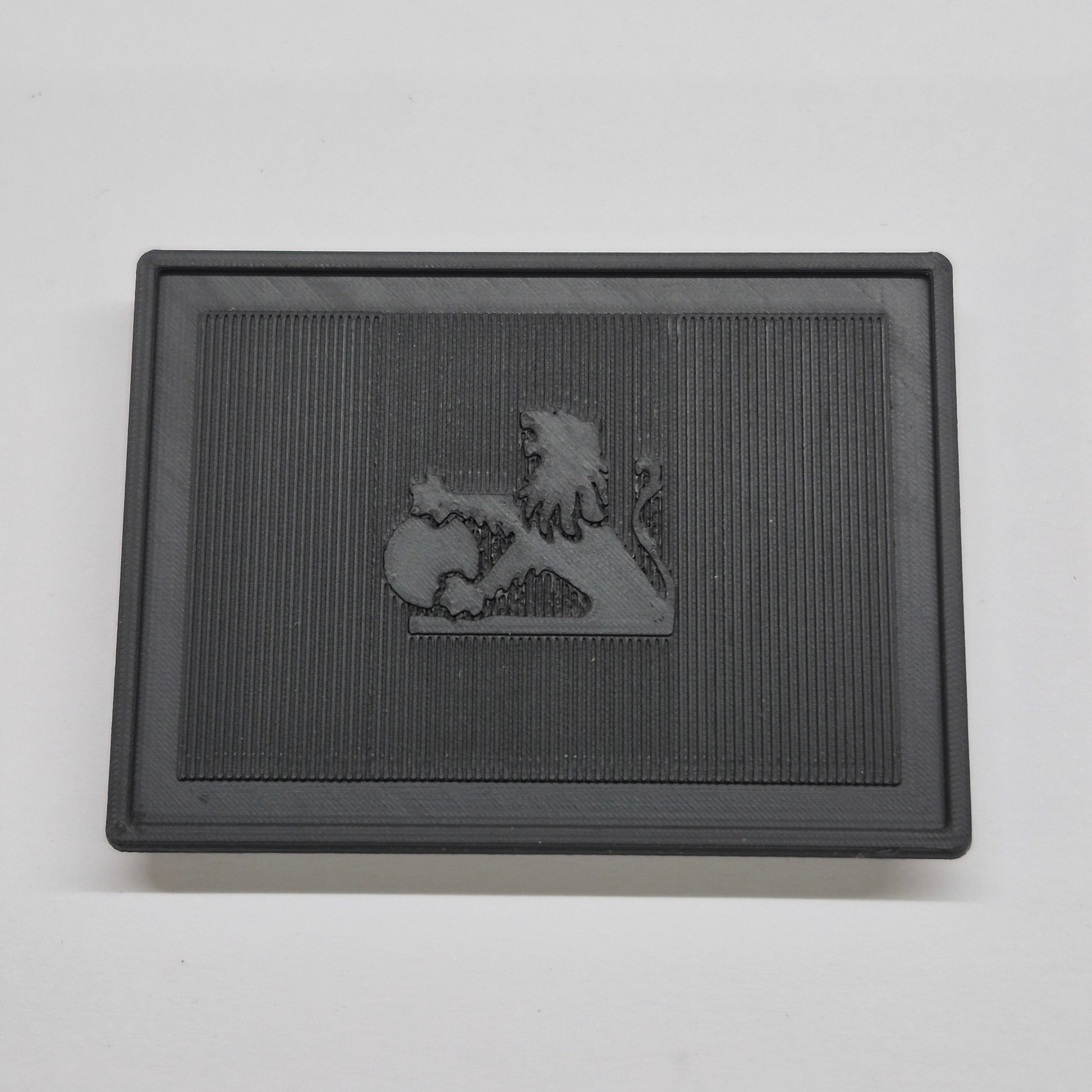 Black rectangular mat with a lion emblem on a gray background