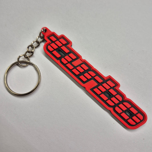 A red and black rubber keychain featuring stylized Chinese characters, attached to a silver metal split ring, shown on a plain light gray background.