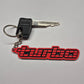 A custom keychain featuring a red and black 'turbo' rubber charm with a keyring and a black key with 'MICA' embossed on the head, displayed on a light gray background.
