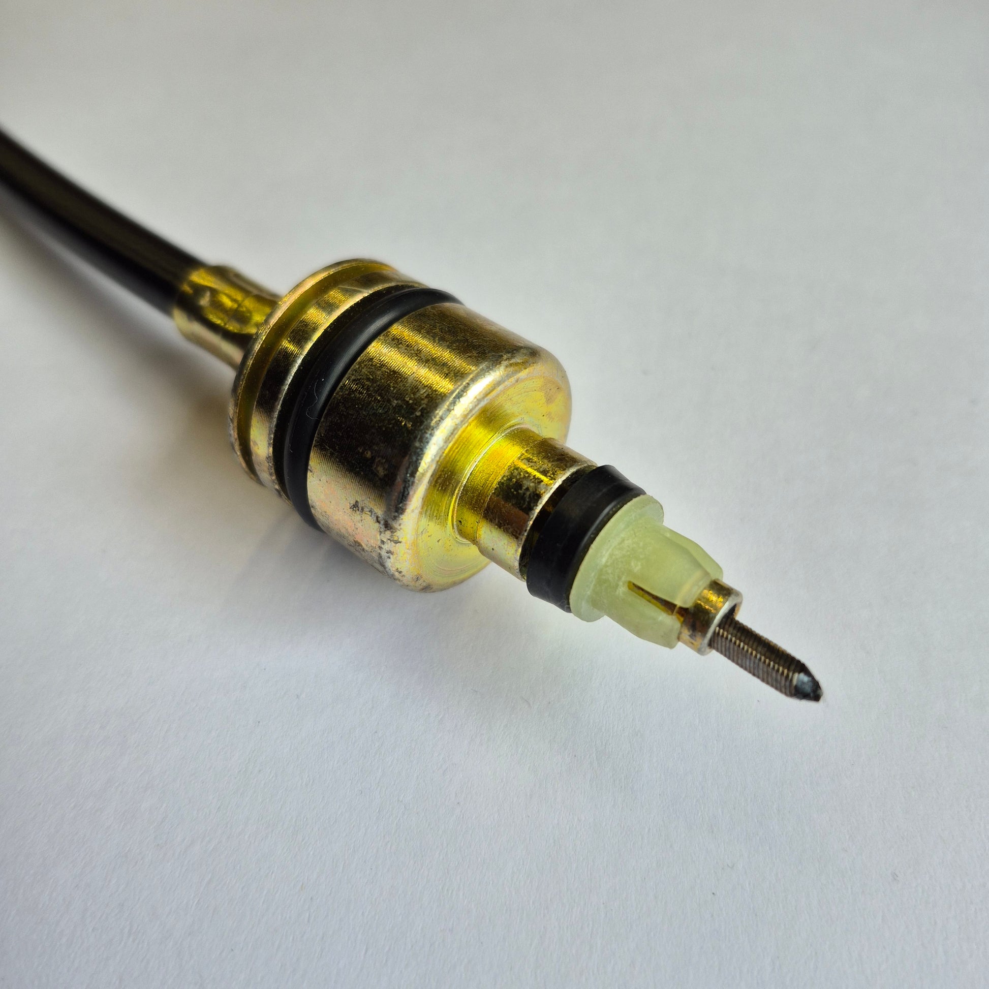 Close-up of a mechanical component with gold and black parts on a white background
