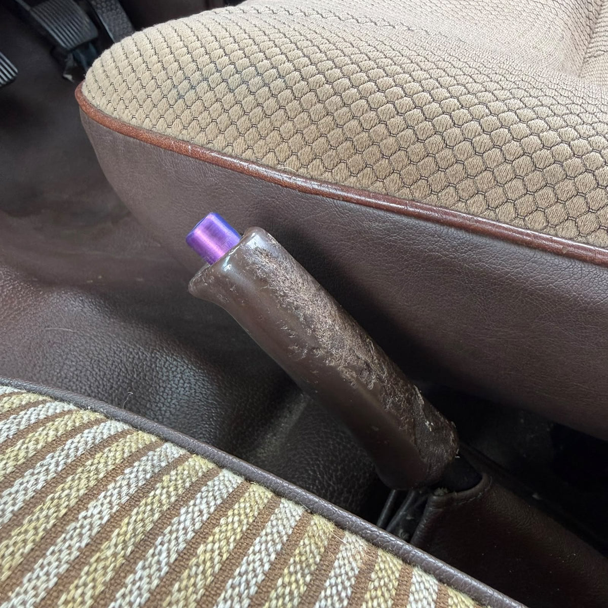 3D printed handbrake button in purple fitted to the brown handbrake lever of a Toyota LandCruiser 60 Series