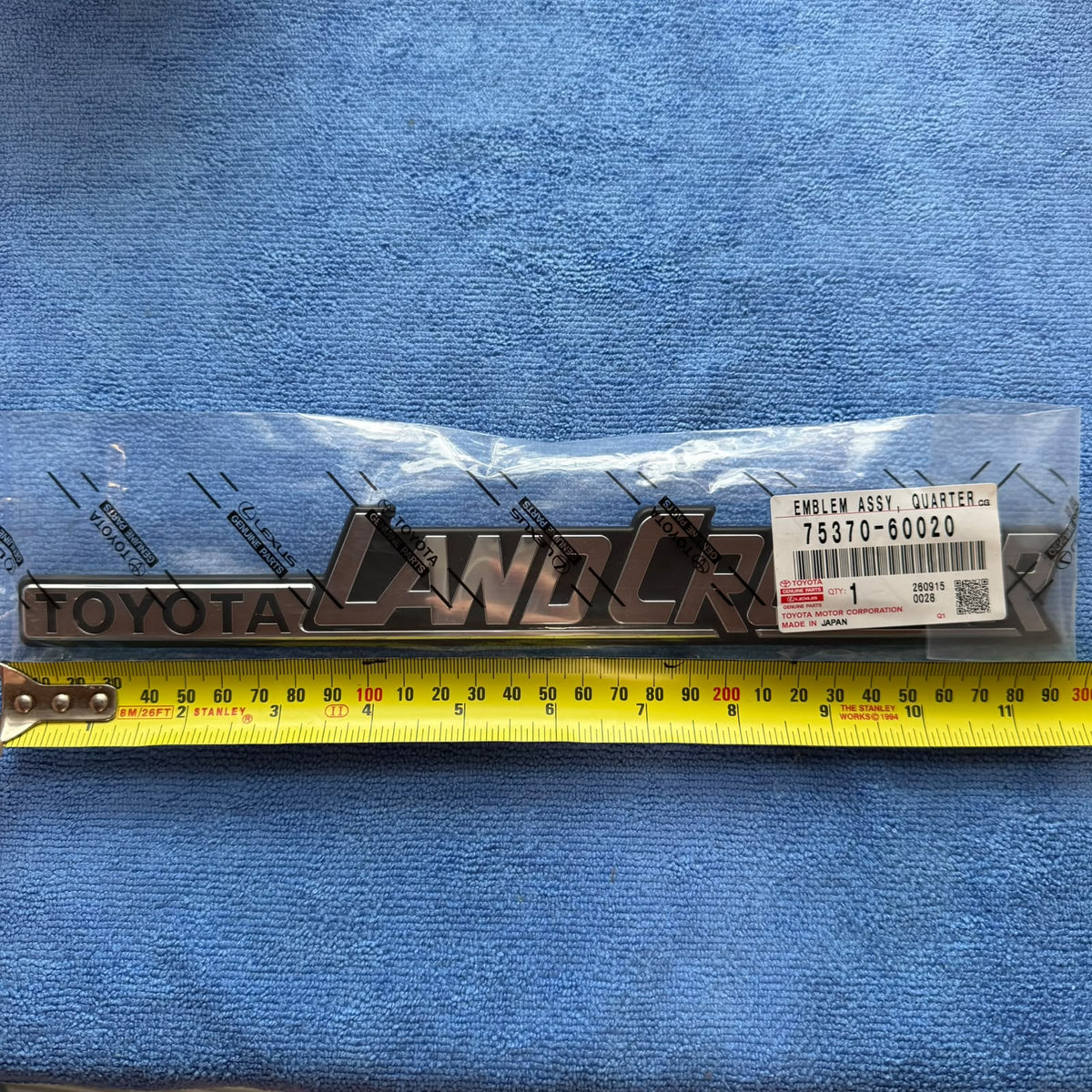 Genuine Toyota LandCruiser 60 Series side emblem 75370-60020 measured with tape, approx 29 cm long
